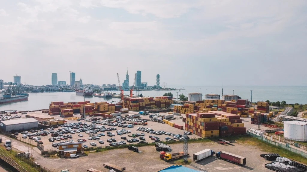 Daytime aerial view of a Turkish free zone port area, with cargo containers, trucks, and warehouses actively supporting export-oriented operations and investment opportunities.