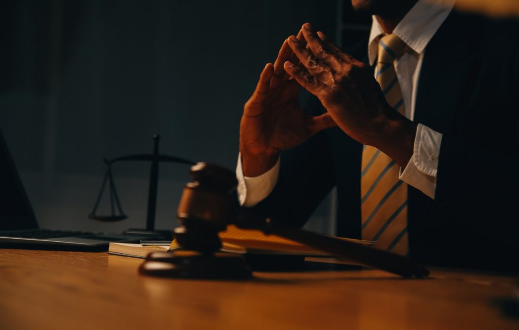 Antalya ceza avukatı müvekkil ile görüşme yaparken – hukuk bürosunda yargı tokmağı ve adalet terazisi eşliğinde