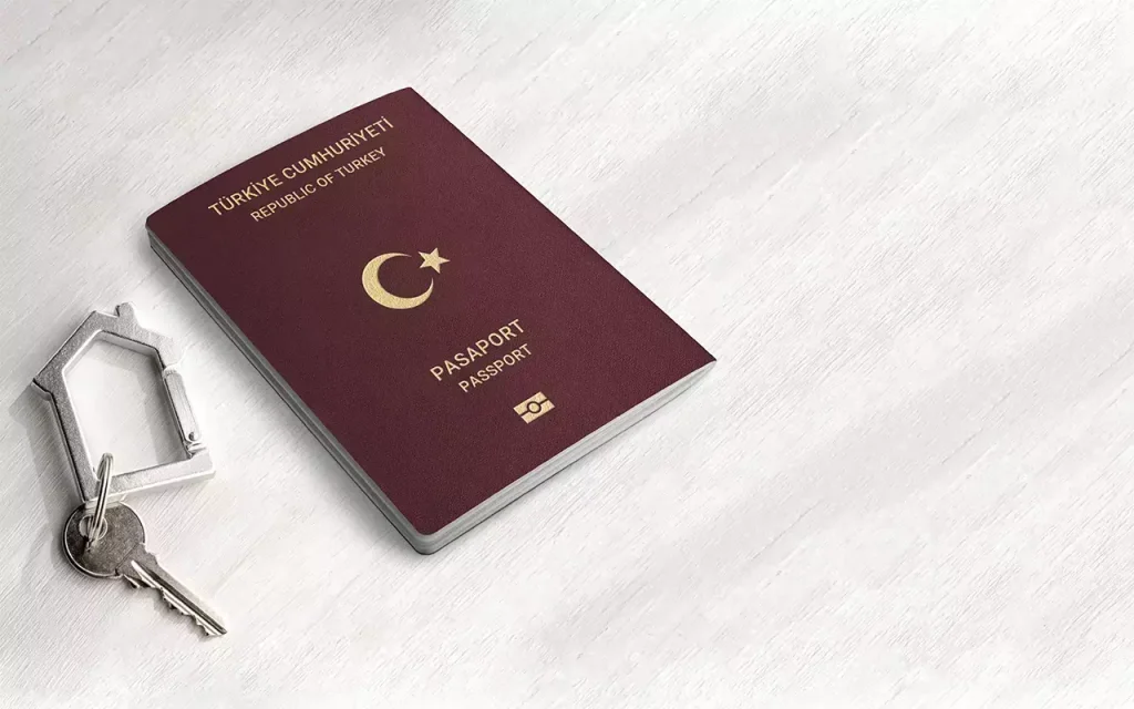 Turkish passport and house-shaped keychain symbolizing Turkish citizenship through real estate investment