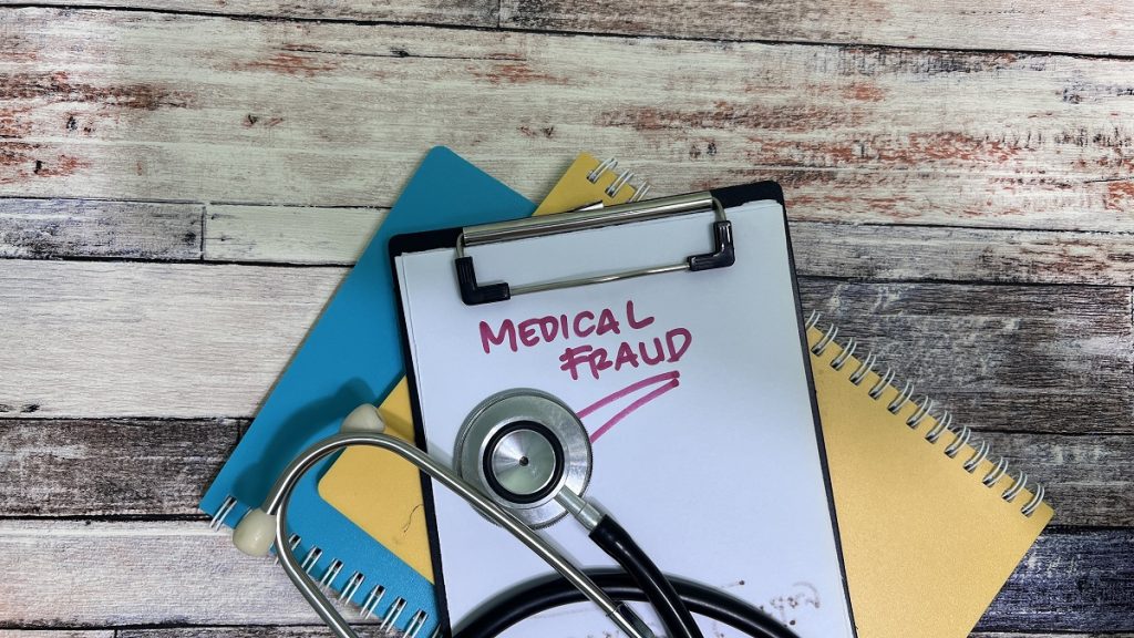 Clipboard with 'Medical Fraud' text and stethoscope on desk, symbolizing deceptive practices in the healthcare industry.