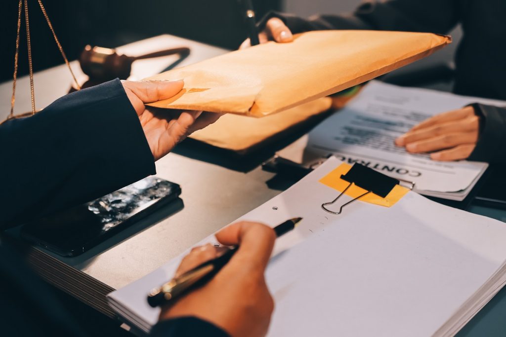 Özel evrakta sahtecilik suçunda (TCK 207) delil olarak değerlendirilebilecek belgelerin teslimi sırasında çekilmiş, savunma stratejilerine dair süreci imgeleyen görsel.