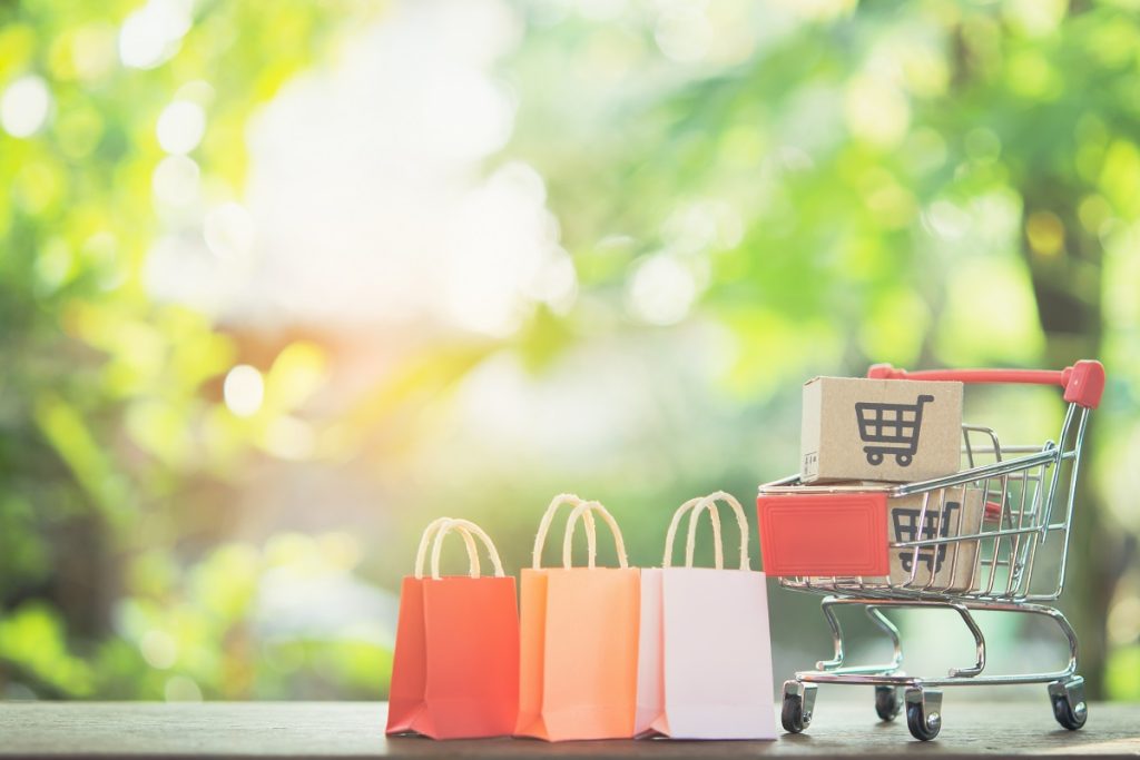 Shopping cart with paper bags and parcel boxes outdoors, symbolizing consumer purchases in Turkey and highlighting foreign buyers’ rights in case of receiving defective products.