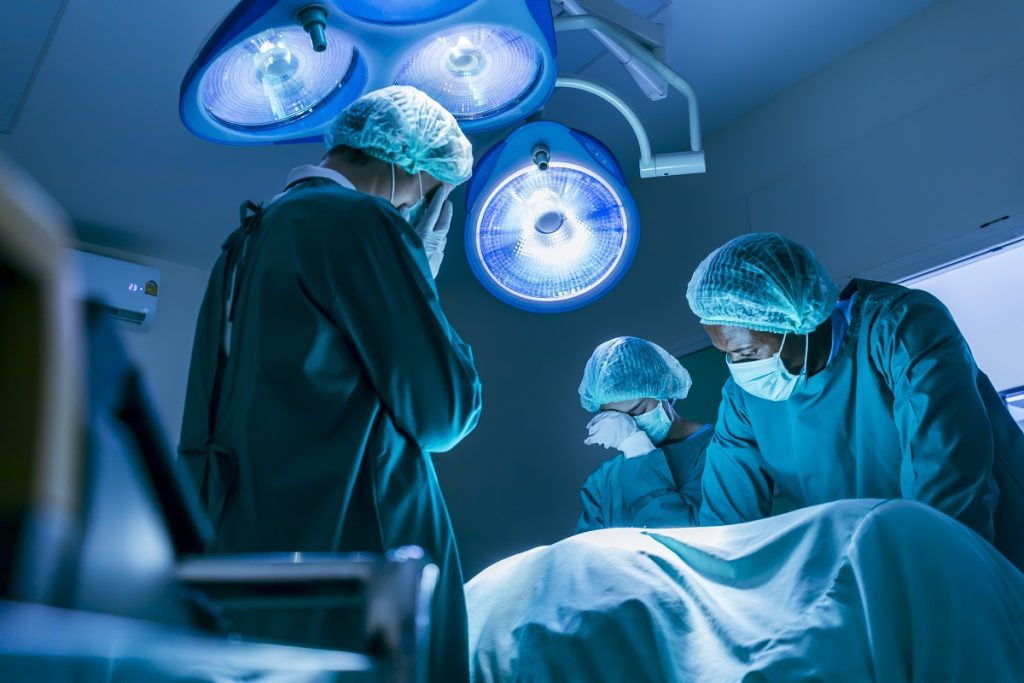 Doctors performing surgery around an operating table, illustrating the context of medical procedures and potential legal actions in 'How to Sue Aesthetic Clinic in Turkey'.