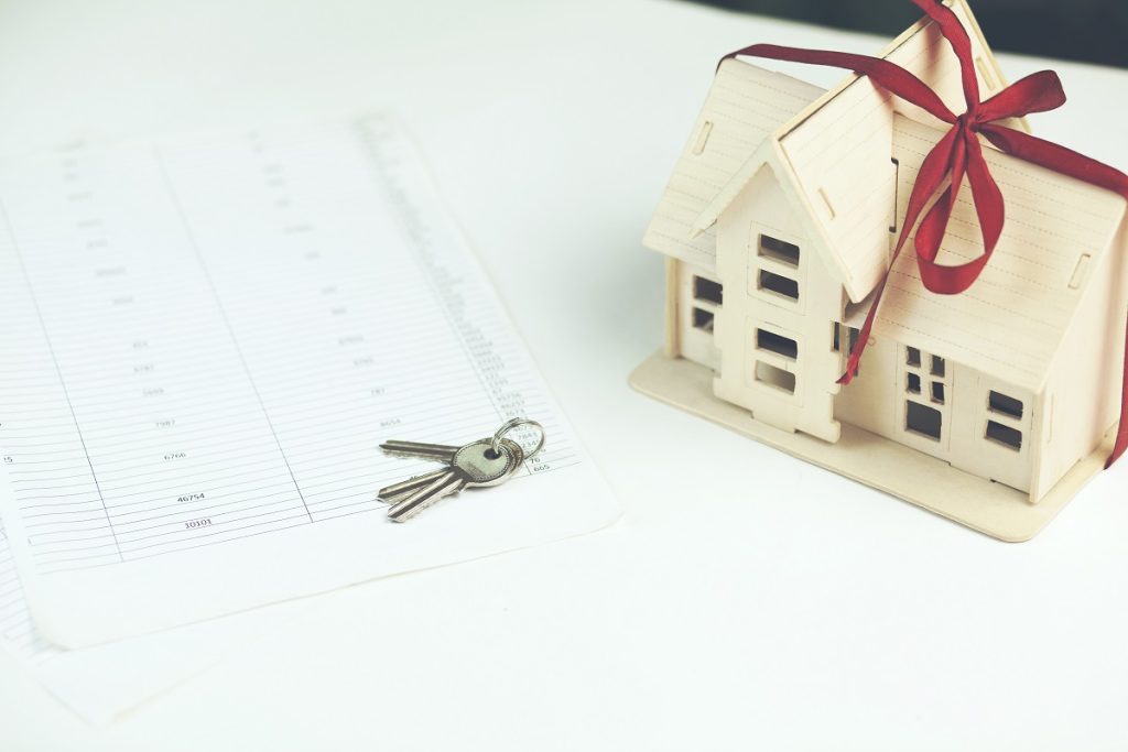 Airbnb izni için gerekli belgeler ve ev anahtarı ile birlikte temsili ev maketi.