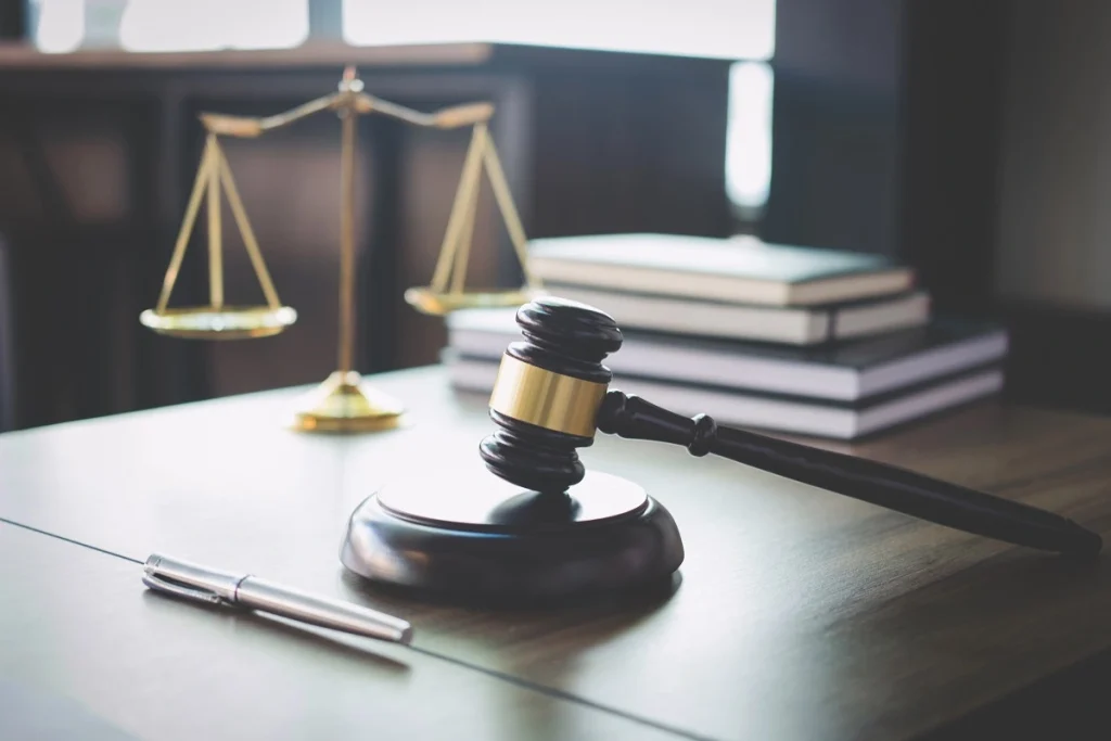 Judge’s gavel, justice scales, pen, and law books representing legal process and authority in turkey visa overstay and entry ban cases.