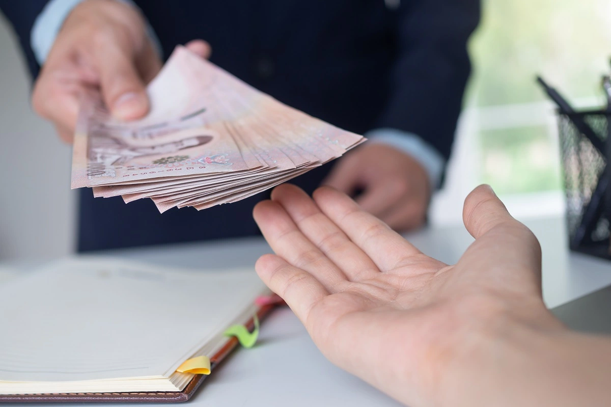 Person handing over money representing the payment of Turkey Overstay Fine Calculator result in 2026
