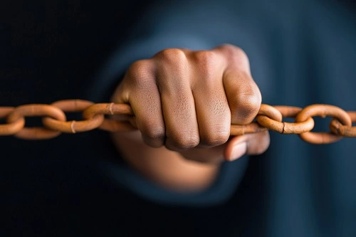 Close-up of a hand gripping a chain symbolizing the need for protection and legal rights under a Restraining Order in Turkey.